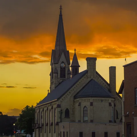 Church spire silhouetted against a golden sunset
