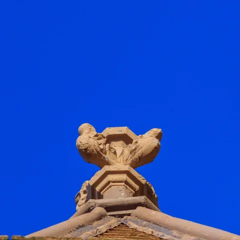 Terracotta finial against a clear blue sky